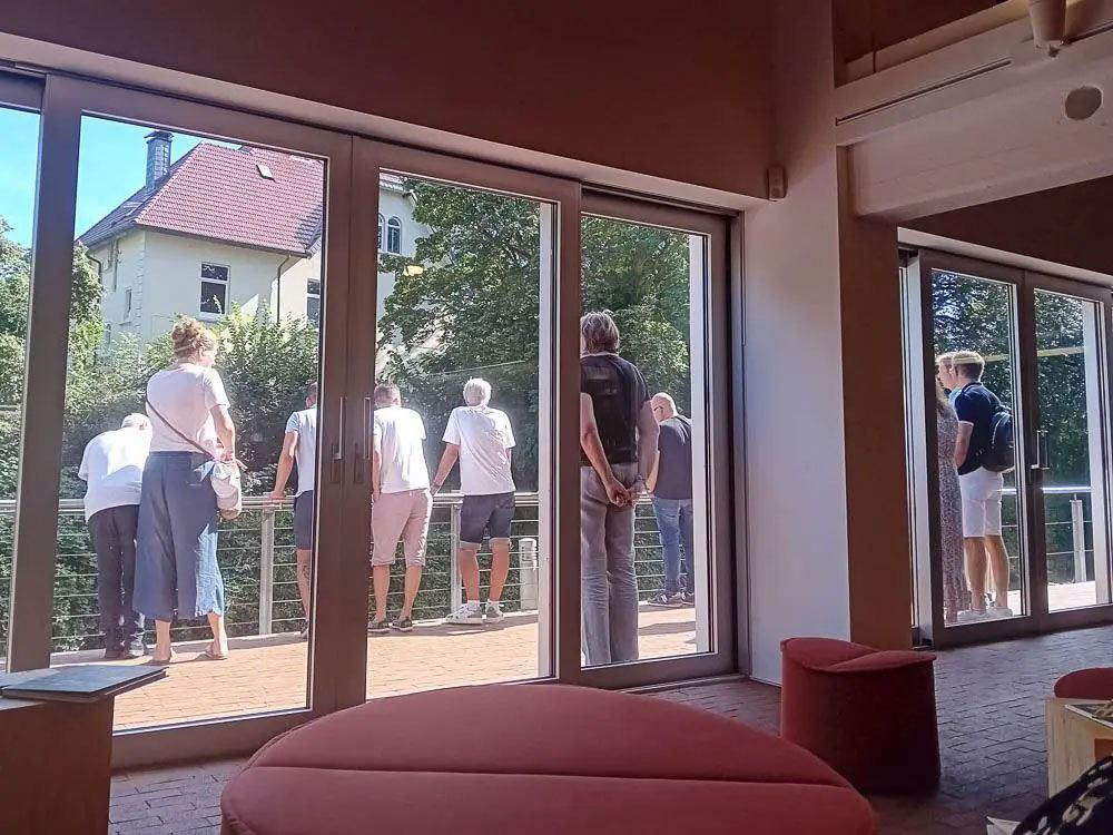 Menschen stehen gemeinsam auf einer Terrasse 